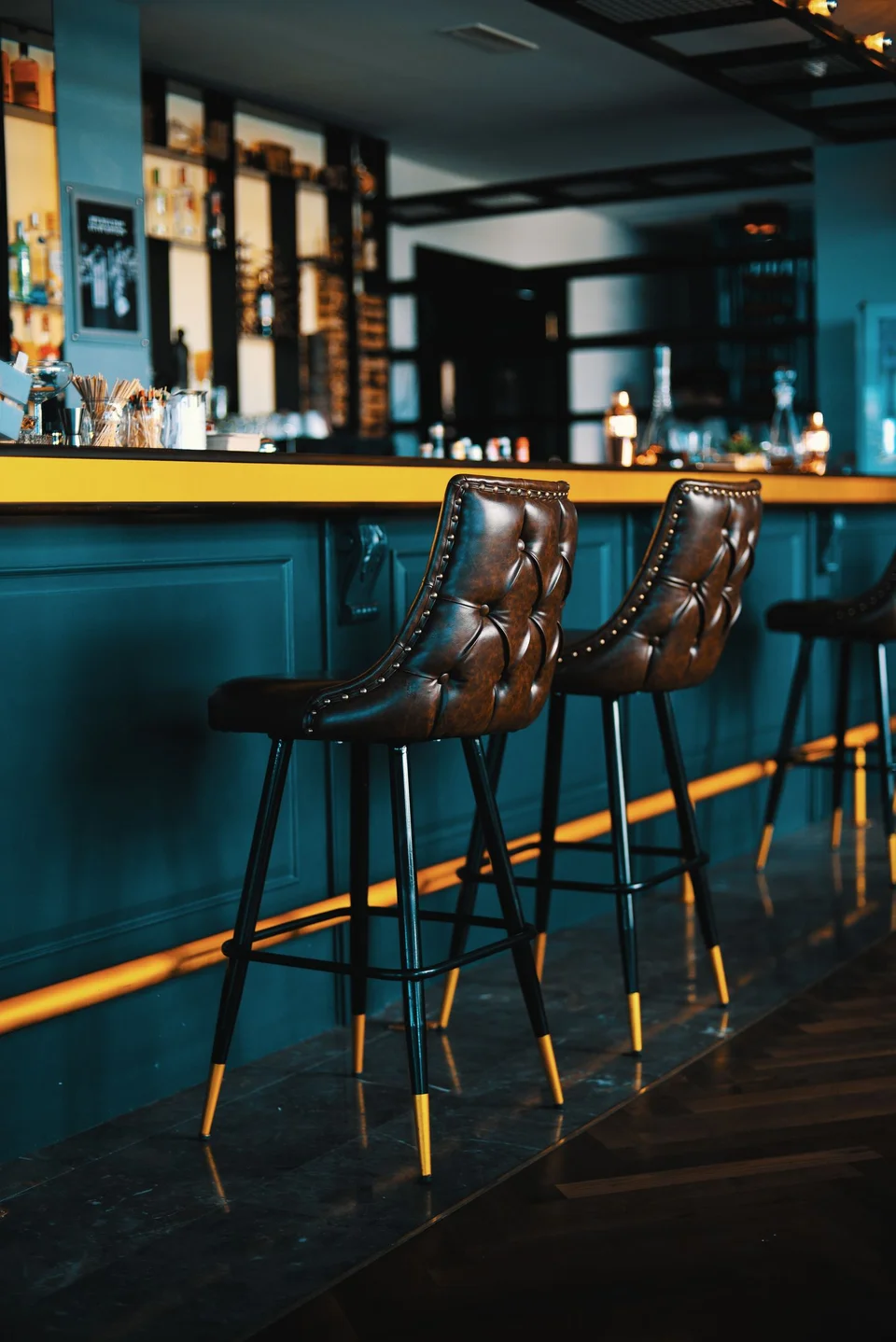 Brown button-tufted upholstered bar stools at a counter