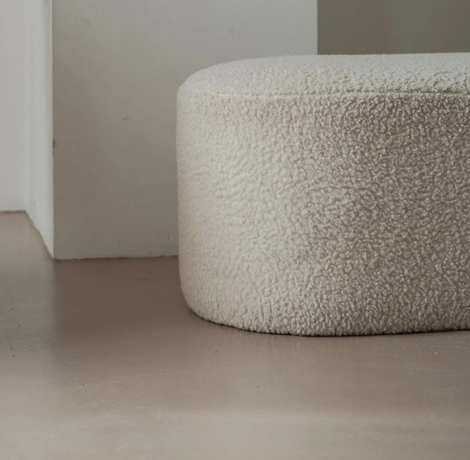 White upholstered footstool with a textured fabric cover